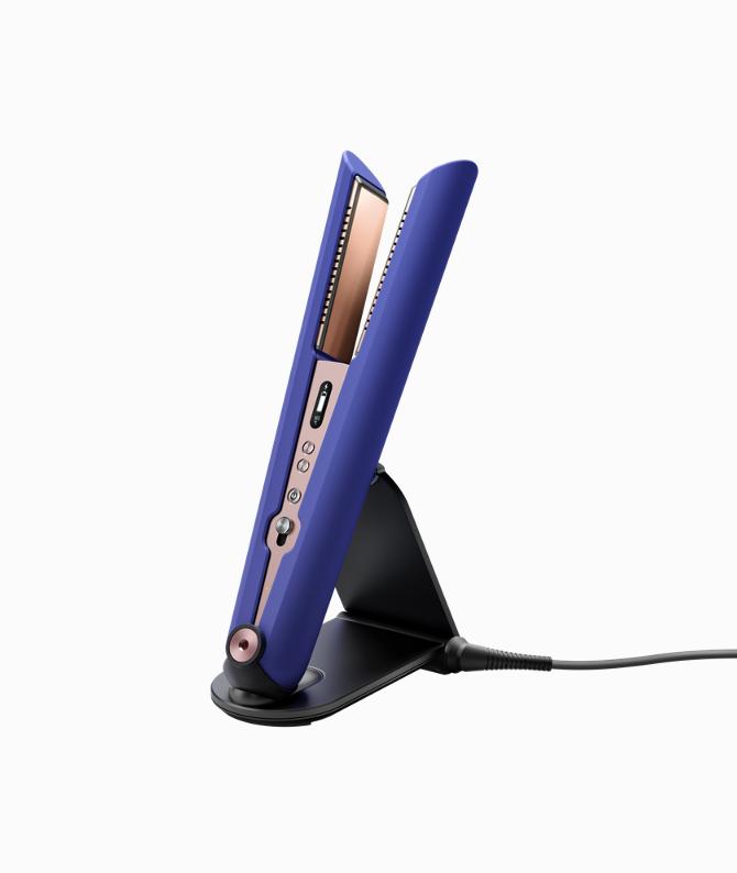 Woman with the Dyson Supersonic hair dryer with the diffuser attachment.